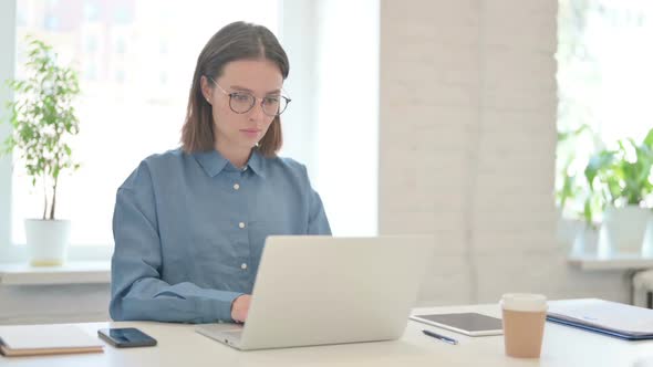 Young Woman Working on Laptop in Office