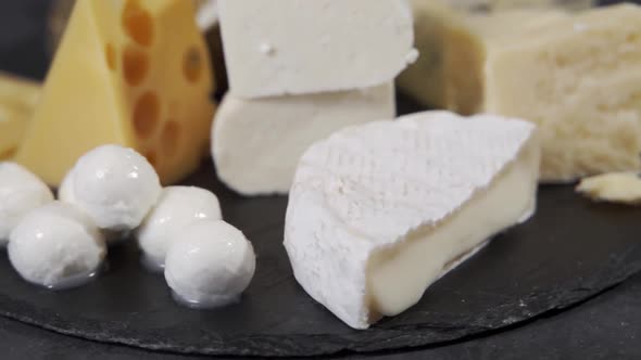 Various Types of Cheese and Other Delicacies on a Rotating Plate