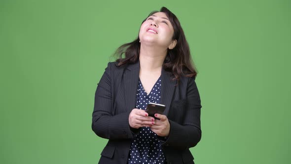 Mature Beautiful Asian Businesswoman Thinking While Using Phone