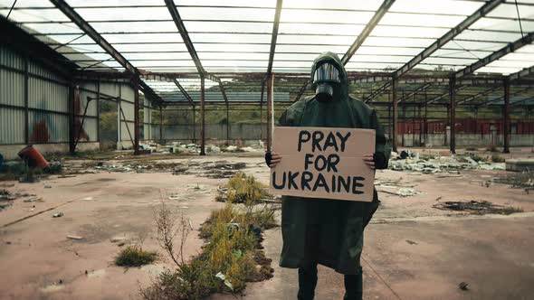 Holding a Pray for Ukraine Placard in a Bombed Area