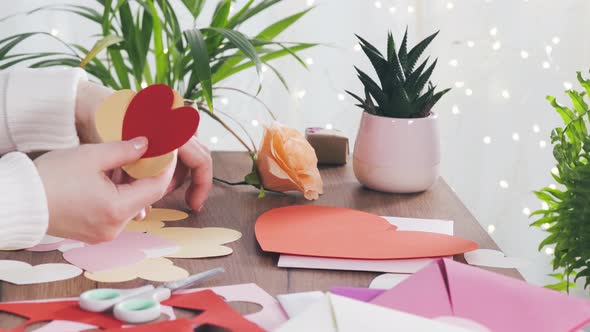 Woman Holding Paper Cut Valentines in Her Hands