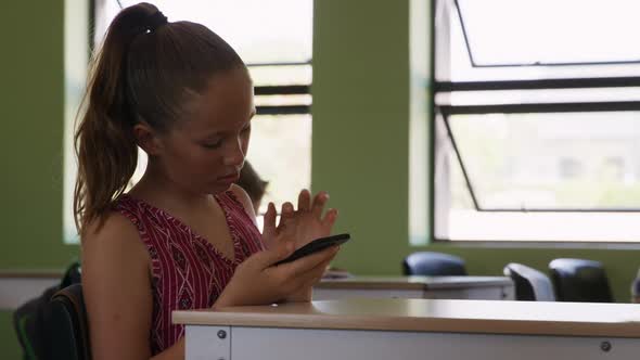 Girl using smartphone in the class