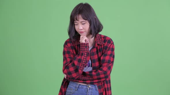 Stressed Asian Hipster Woman Thinking and Looking Down