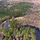 Aerial view of the river between the pines. Flying over a winding riverbed surrounded by treetops - VideoHive Item for Sale