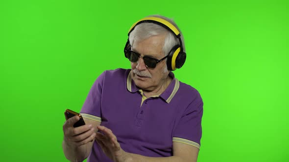 Elderly Stylish Caucasian Grandfather Man Using Social Media App on Smartphone