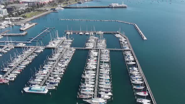 AERIAL Tilt Down Over Luxury Vessels Moored In A City Bay