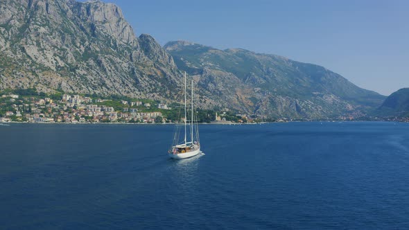 Sailing Yacht in the Water Against the Backdrop of the Mountains White Sailingboat in the Bay of