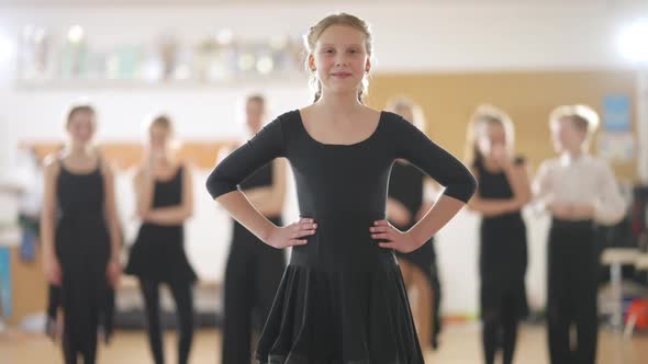 Confident Skilled Teenage Girl Standing in Dance Studio Looking at Camera Smiling and Making Curtsy