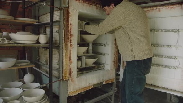 Man Potter Is Removing Ceramics From Kiln