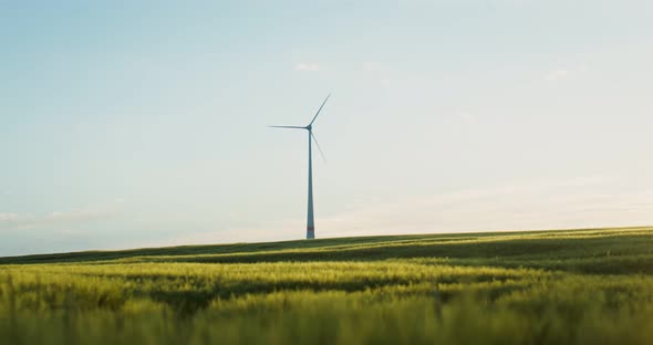 A View of a Green Valley with a Wind Generator Standing Among the Fields