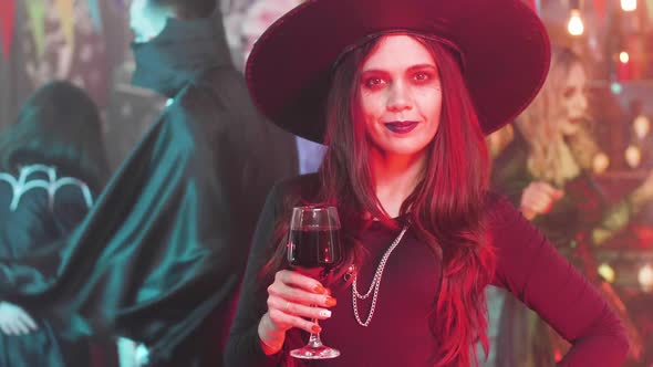 Woman Dressed in Evil Witch Costume Drinks Blood From a Glass