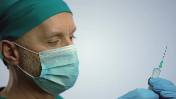 Therapist in Face Mask Making Medicine Injection With Syringe, Vaccination