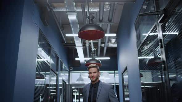 Cheerful Man Waiting for Meeting in Office. Businessman Standing in Corridor