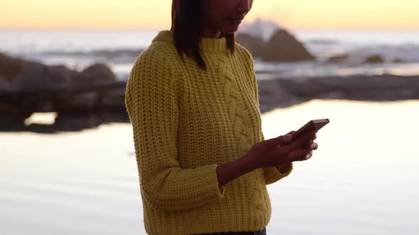 Woman using mobile phone on the beach 4k