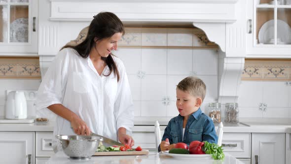 Agility Smiling Kid Stealing or Taking Slice of Food While Mother is Cooking