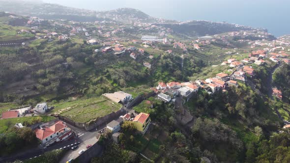 Sea views looking over houses and fields in Ponta Do Sol in Madeira. Shot on DJI.