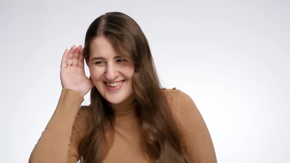 Suspicious Smiling Woman Overhearing Someone's Talk and Holding Hand Next to Ear