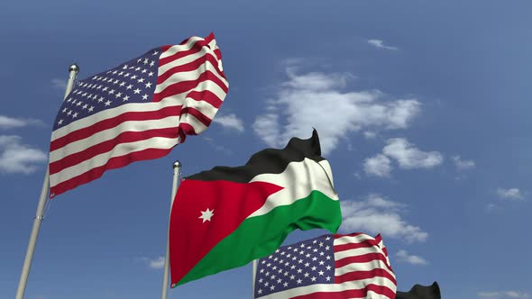 Waving Flags of Jordan and the USA on Sky Background