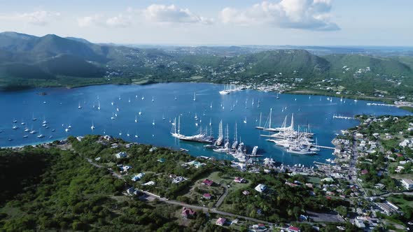 Yachts in a city bay on the island with forest and mountain in Falmouth Harbour, Antigua and Barbuda