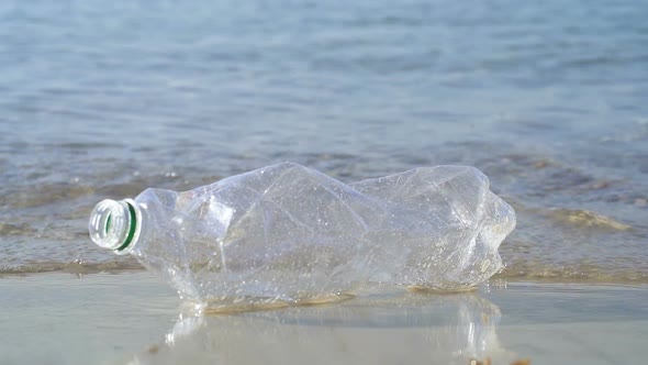 Plastic bottle literring and the clean beach. Slowmotion