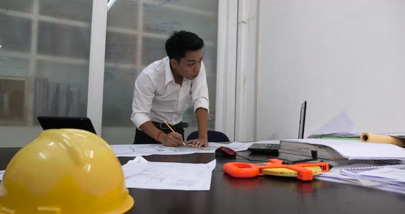 Male Architect Working With Blueprints In The Office alt