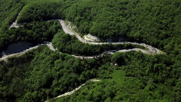 Aerial View of a Curved Winding Road with Cars Passing