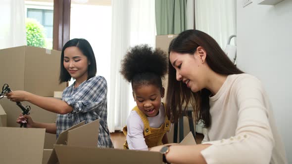 LGBT Family Unpacking Boxes In New Home On Moving Day.