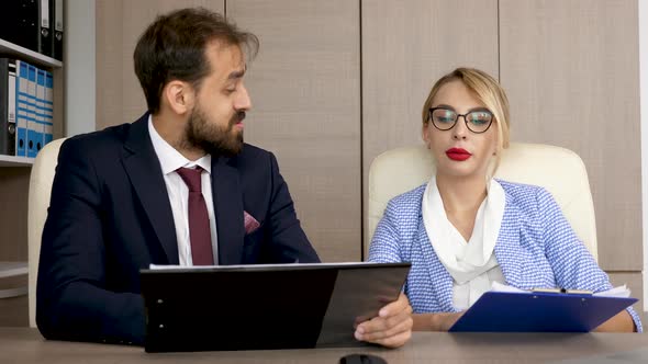 Two Business Partners Discussing and Analyzing Strategy Business on Clipboards with Charts