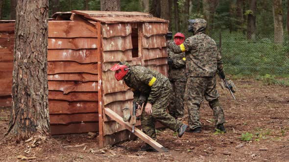 Paintball Sport Player Wearing Protective Mask Aiming Gun Shelter Under Attack