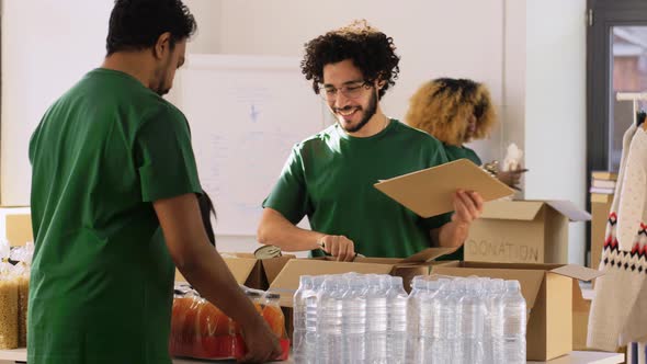 Group of Volunteers Packing Food in Donation Boxes