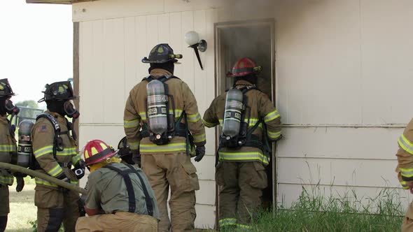 Firemen at doorway of smoking house