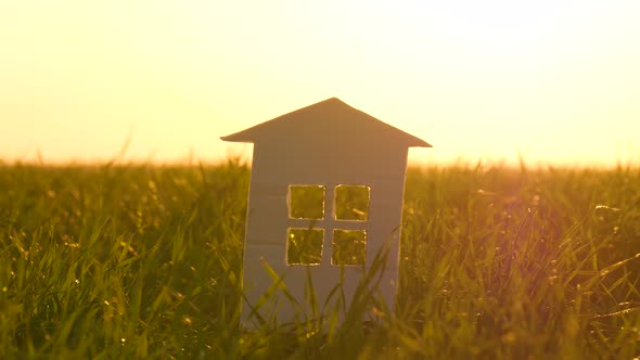 The Silhouette of a Paper House on the Background of a Beautiful Sunset. Paper House on a Background