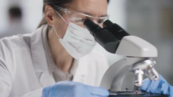 Female Scientist in Face Mask Doing Research