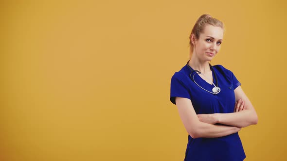 Portrait of an Young Attractive Blond Female Nurse Posing Against Orange Background Isolated Copy