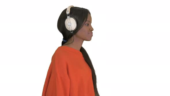 Smiling African American Woman with Headphones Walking Listening To the Music on White Background