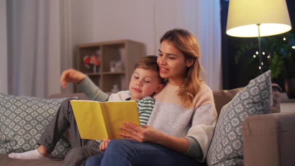 Happy Mother and Son Reading Book Sofa at Home