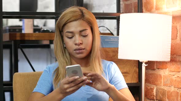 Black Girl Browsing Smartphone at Work