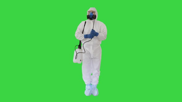 Man in a Protective Suit and Mask Holding a Disinfectant Ready To Work on a Green Screen, Chroma Key