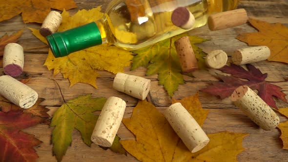 Wine bottles on an old vintage wooden board and falling corks. Slow motion.