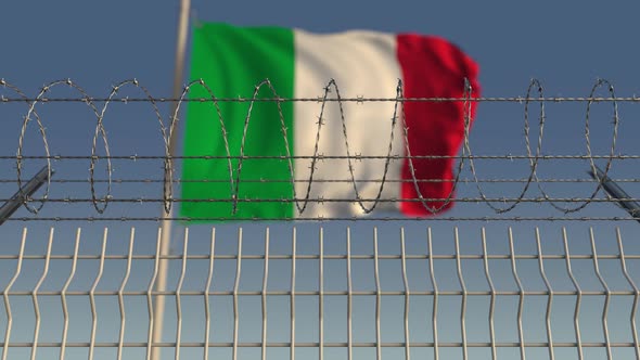 Waving Flag of Italy Behind Barbed Wire Fence