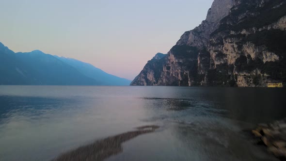 Aerial view from beach to Garda lake, in Riva del Garda, Italy, at sunrise. Drone goes up