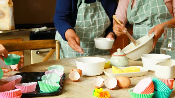 Siblings preparing food with family in kitchen 4k