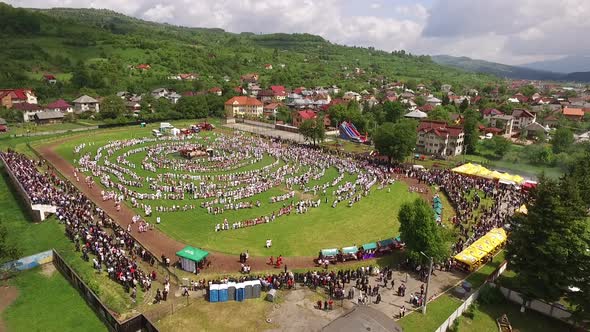 Aerial view of people in peasant clothes at a stadium