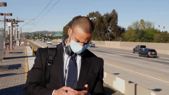 Businessman wearing a face mask waits for train