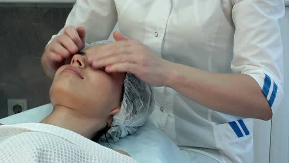 Young Masseuse Giving an Attractive Woman Neck and Shoulders Massage at Beauty Spa