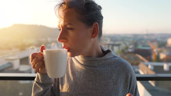 Woman Starts Her Day with a Cup of Tea or Coffee and Checking Emails in Her Smartphone on the