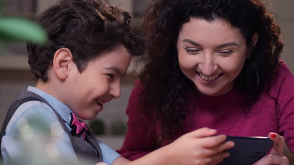 Close Up Happy Mom and Son Watching Funny Video