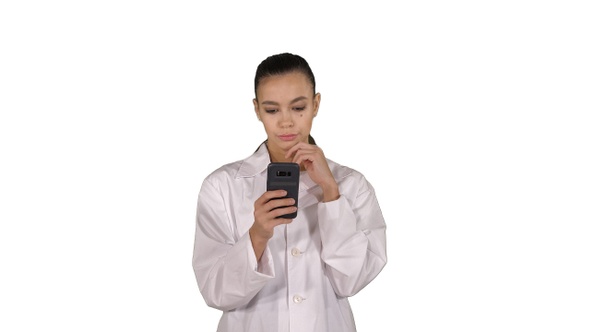 Cheerful Cute Young Woman Doctor Typing Text on Phone While