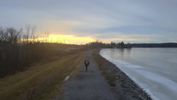 aerial drone following a young woman on a winter day