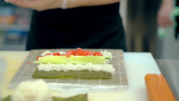 Close Up Cooking Japanese Rolls Using Mat with Cucumber and Ginger